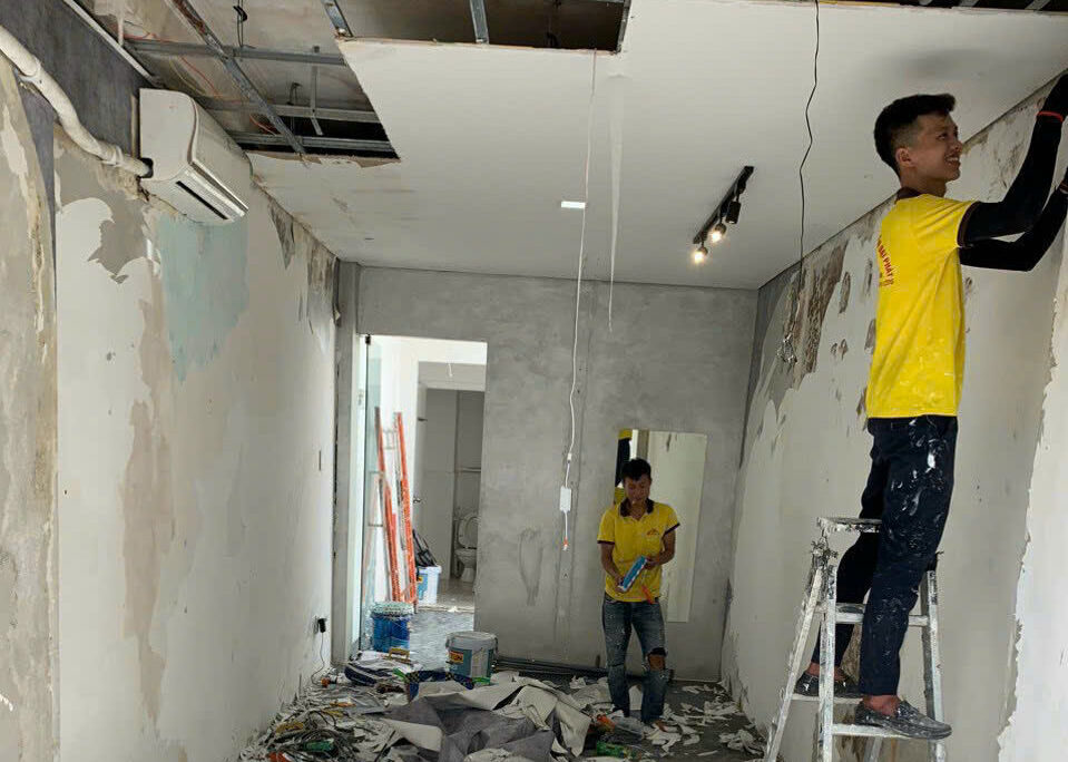 chống thấm gốc dầu lên tường ngoài thợ đang xủi hết phần bị thấm ố của tường và trần nhà