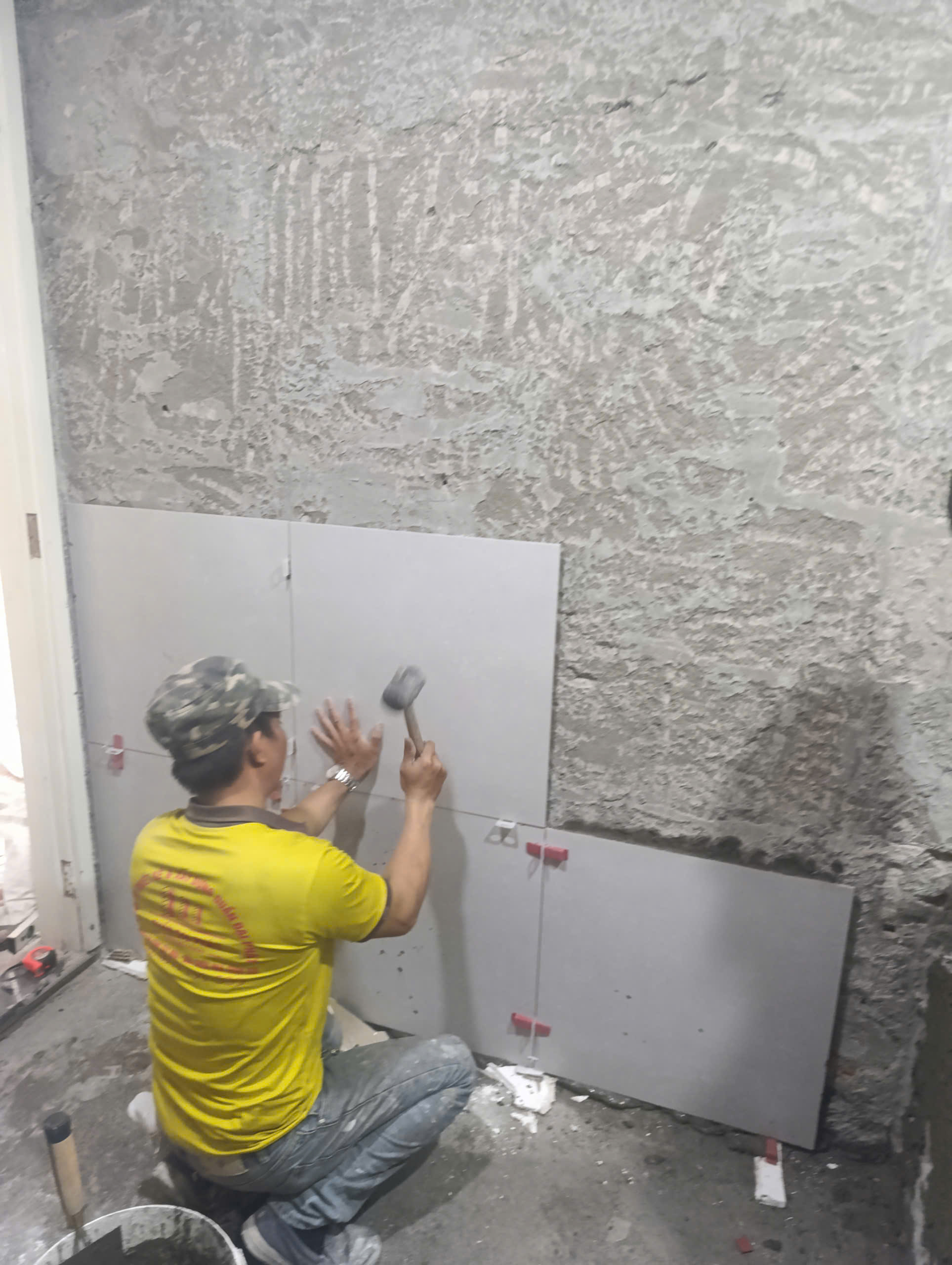 thợ d-home 24h đang tiến hành ốp lát lại gạch nhà vệ sinh sau khi cải tạo